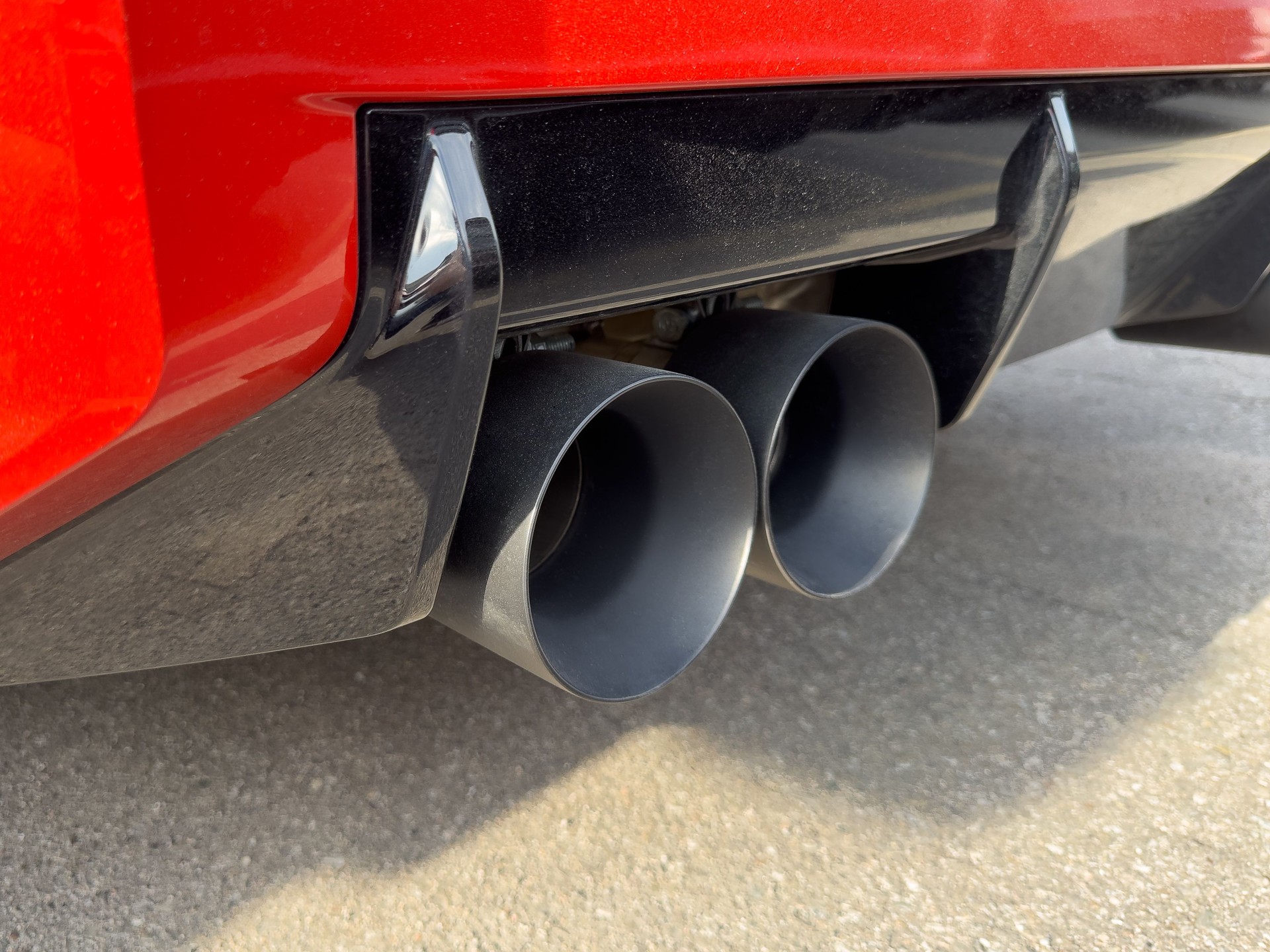Dual Matte Black Titanium Large Exhaust Tips Pipes Red Sports Car Closeup Sound Rear Bumper Outdoor